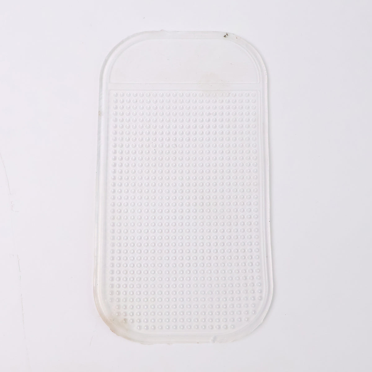 Large transparent silicone anti-slip mat on a car dashboard holding a phone, view 4