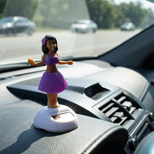 Solar powered dancing hula girl doll in purple dress on car dashboard, view 2