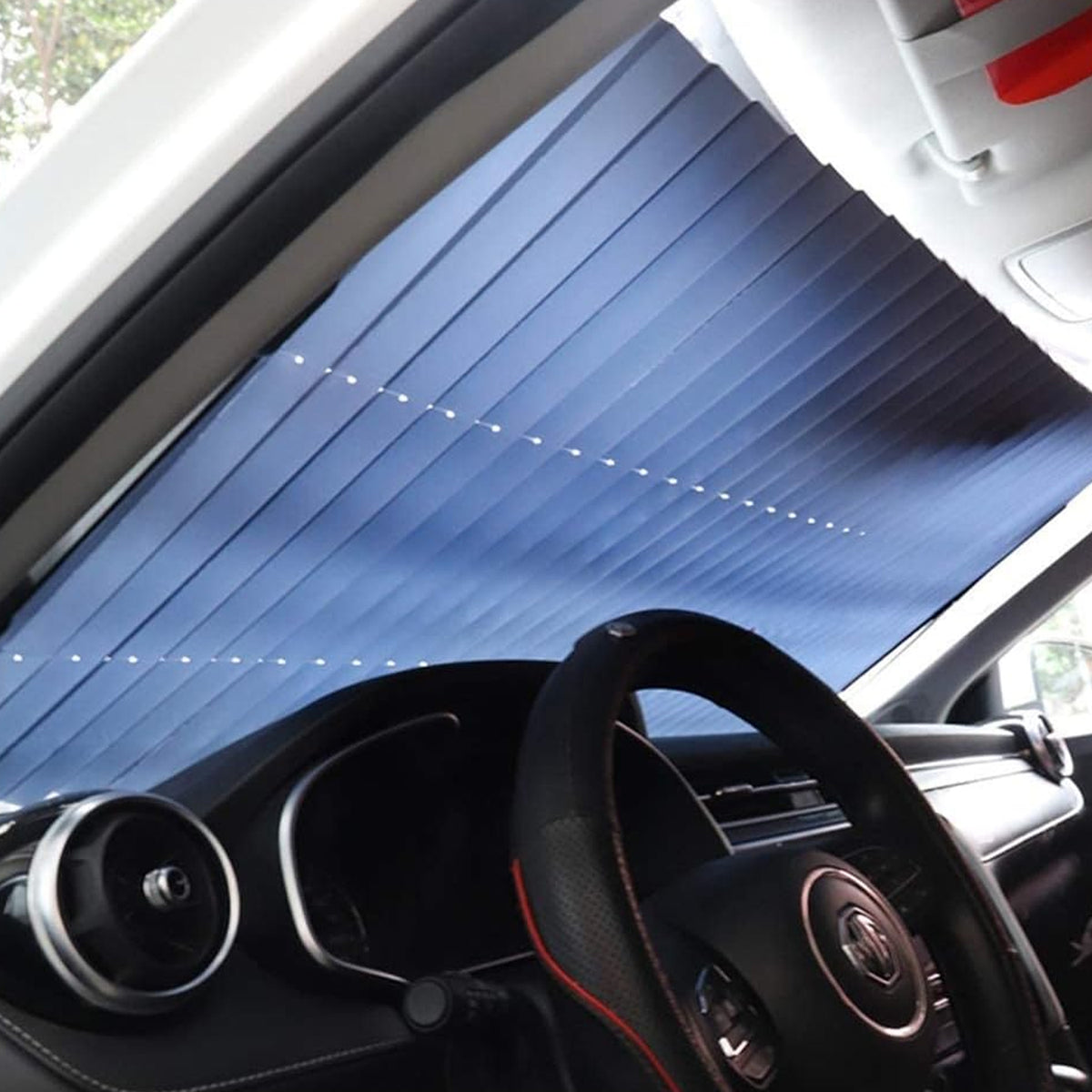 Retractable roller sun shade fixed across a car windshield with suction cups, view 6