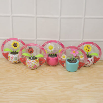 Solar dancing flower toy in a colourful pot on a car dashboard, view 6