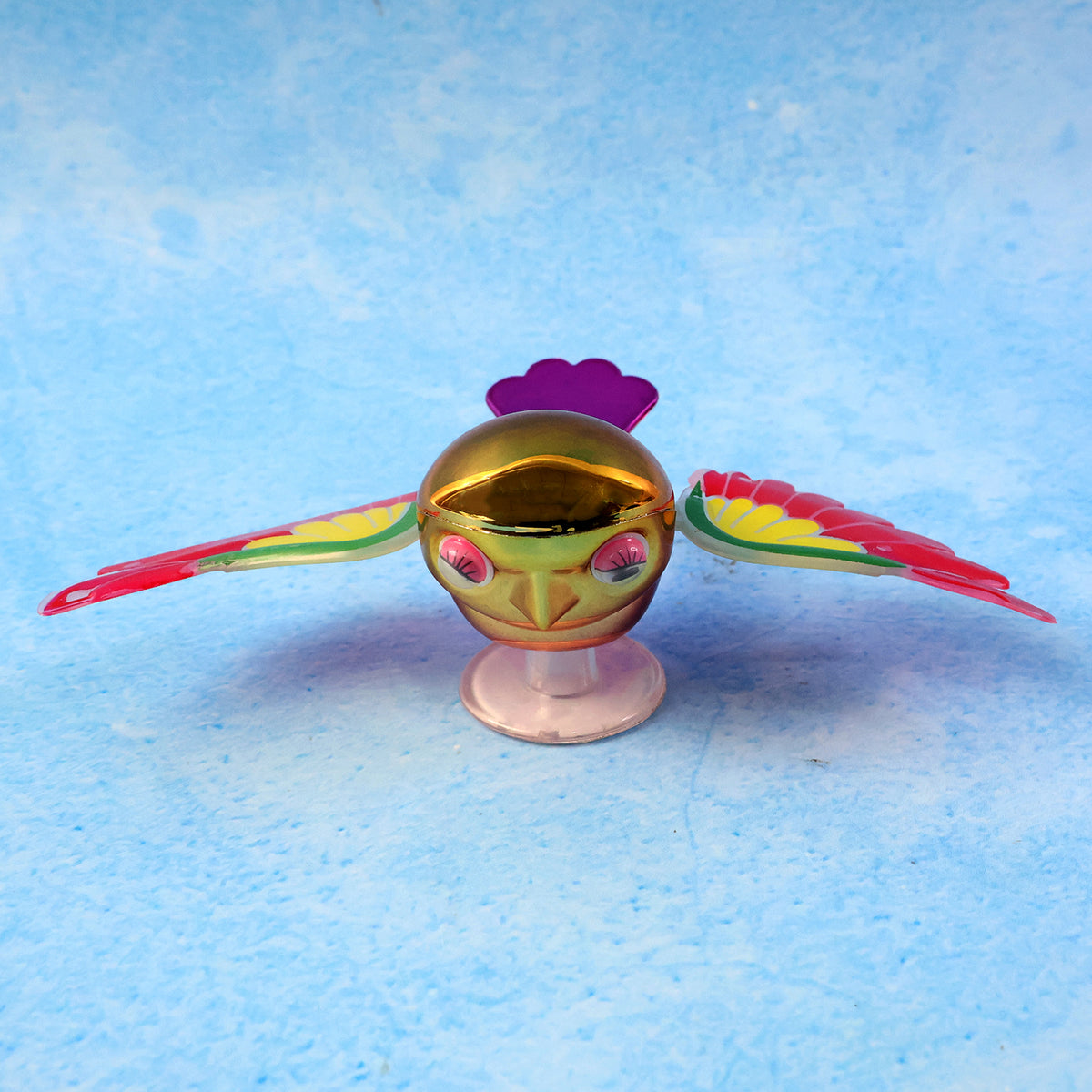 Colourful wind flying bird decoration on a car dashboard, view 6