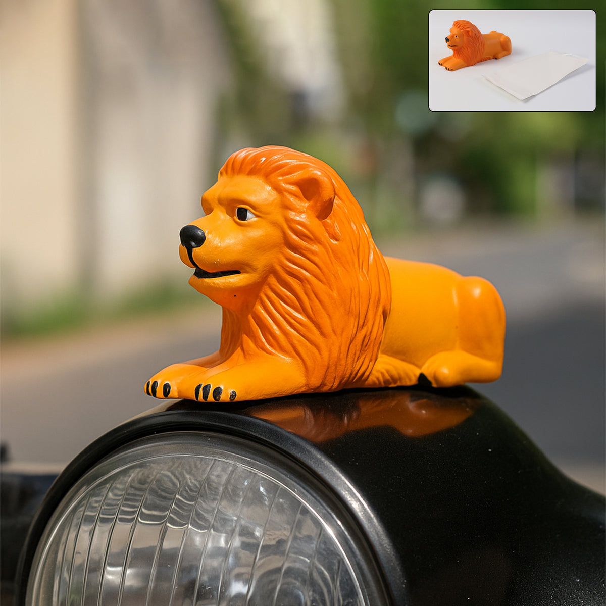 Golden orange lion figurine in a lying pose on a car dashboard