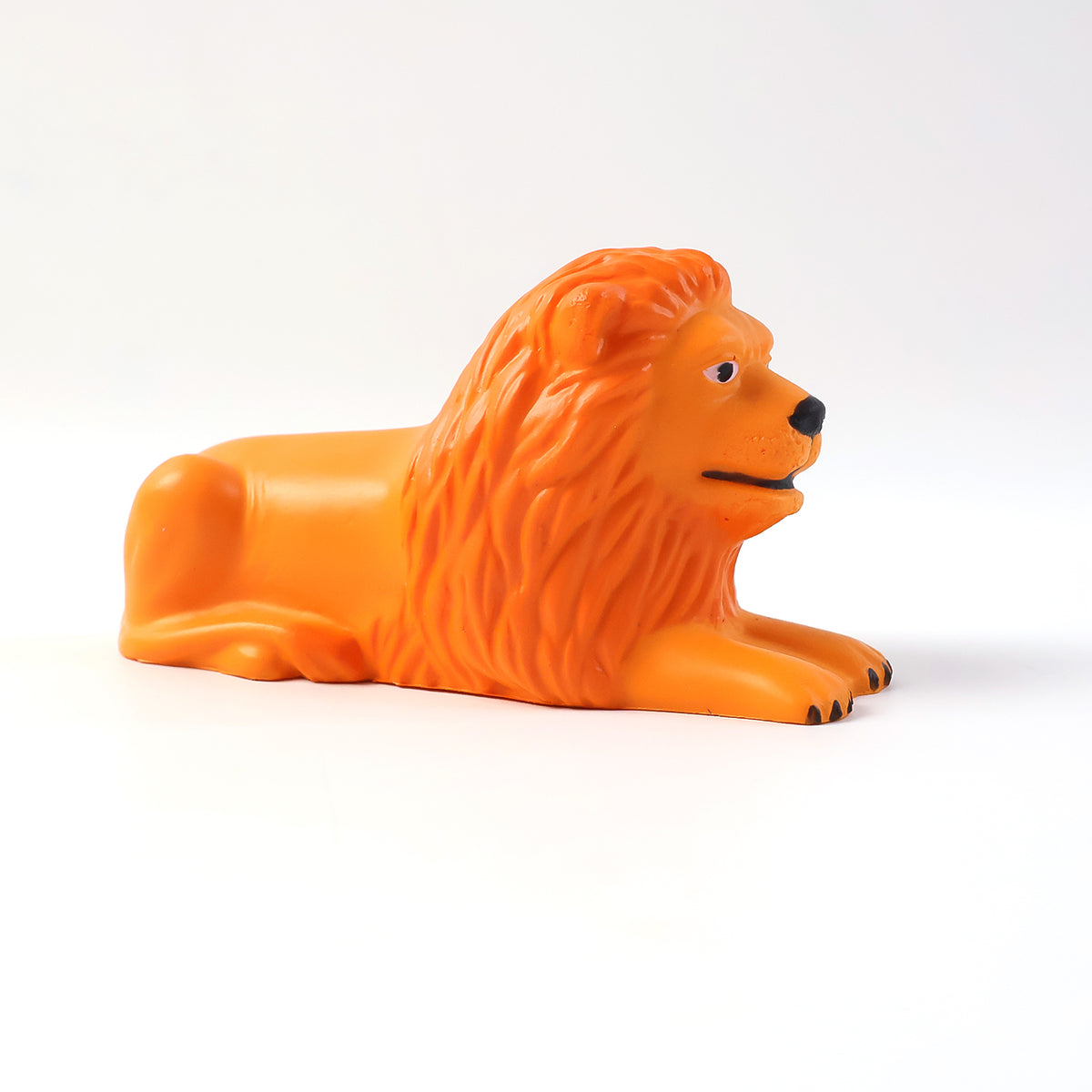 Golden orange lion figurine in a lying pose on a car dashboard, view 4