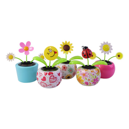 Solar dancing flower toy in a colourful pot on a car dashboard, view 3