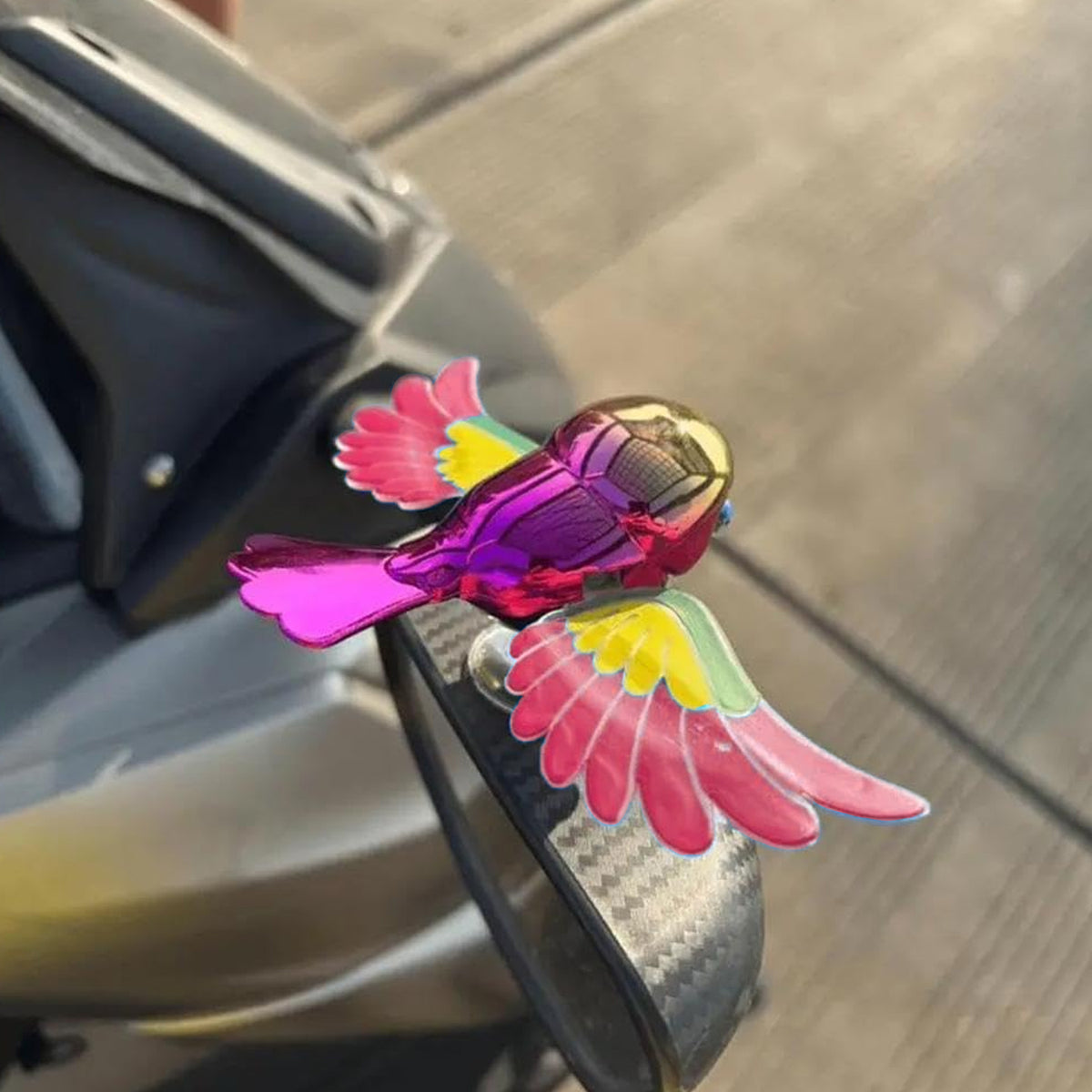 Colourful wind flying bird decoration on a car dashboard, view 3