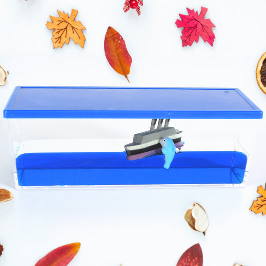 Clear acrylic ornament with a floating cruise ship and iceberg in blue liquid